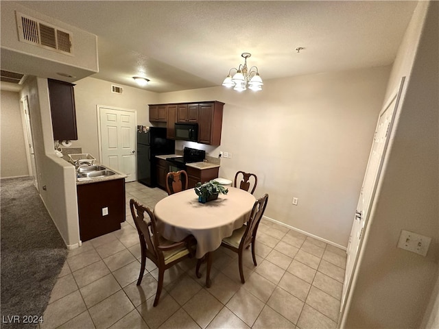 dining area with light tile patterned floors, sink, a chandelier, and a textured ceiling