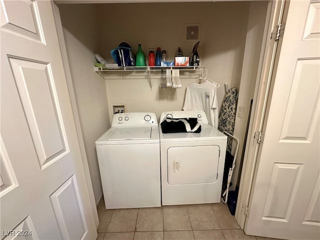 laundry area with light tile patterned flooring and washer and dryer