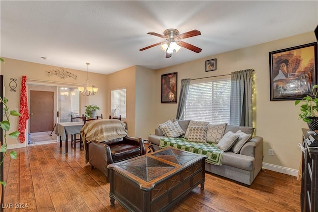 living room featuring ceiling fan with notable chandelier and hardwood / wood-style floors