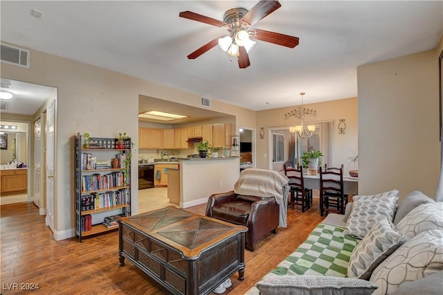 living room featuring light wood-type flooring and ceiling fan with notable chandelier