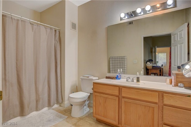 bathroom with toilet, vanity, and tile patterned floors