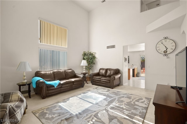 living room featuring a high ceiling and light carpet