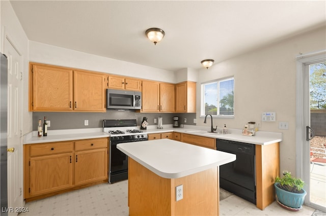 kitchen featuring black appliances, a kitchen island, and sink