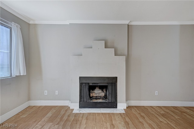 unfurnished living room with crown molding, baseboards, and wood finished floors