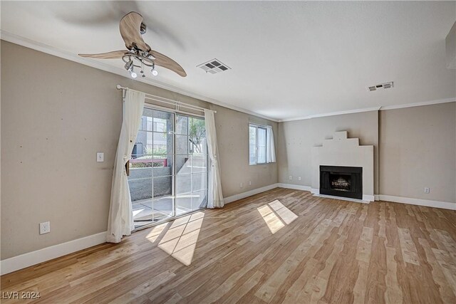 unfurnished living room featuring light hardwood / wood-style floors, ceiling fan, and ornamental molding