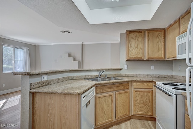 kitchen with visible vents, light wood-style floors, a sink, white appliances, and a peninsula