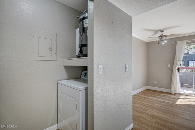 washroom with laundry area, baseboards, electric panel, light wood finished floors, and washer / dryer