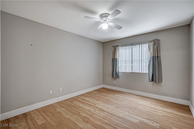 spare room with a ceiling fan, baseboards, and wood finished floors