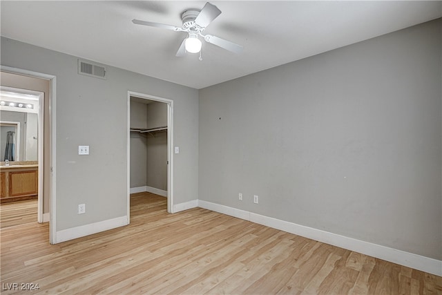 unfurnished bedroom featuring light wood-type flooring, baseboards, visible vents, and a closet