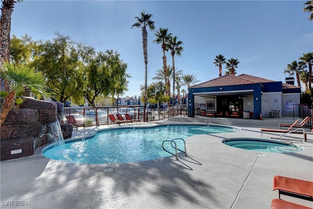 community pool with a patio area and fence