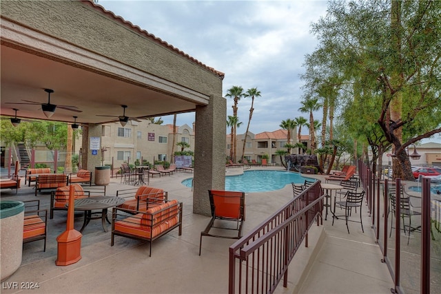 community pool with a patio area and ceiling fan