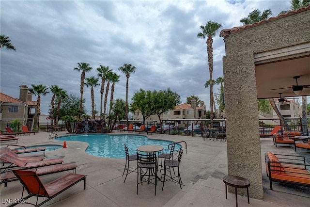 pool featuring a patio, fence, and a hot tub