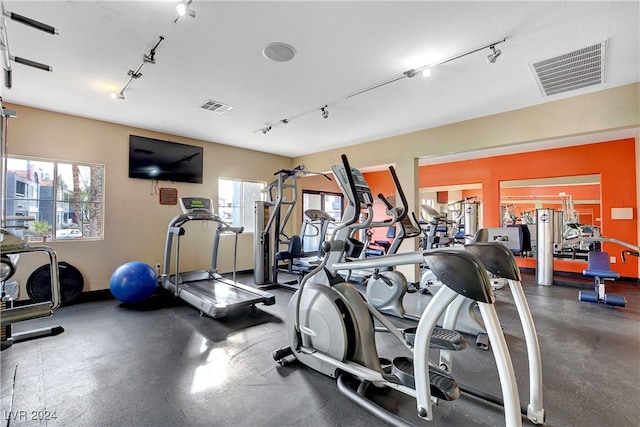 gym with rail lighting, visible vents, and a wealth of natural light