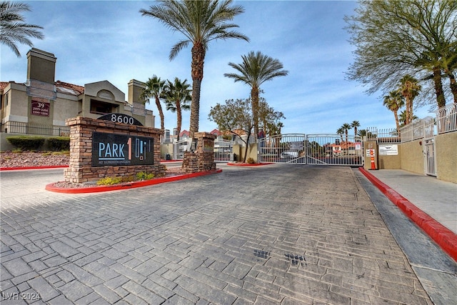 view of road featuring a gate, a gated entry, and curbs