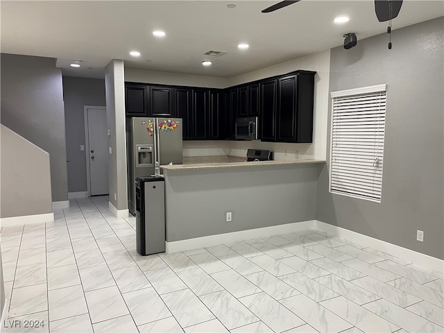 kitchen with kitchen peninsula, ceiling fan, and stainless steel appliances