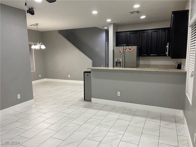 kitchen with an inviting chandelier, pendant lighting, and stainless steel refrigerator with ice dispenser