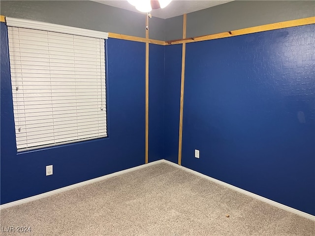 carpeted spare room featuring ceiling fan