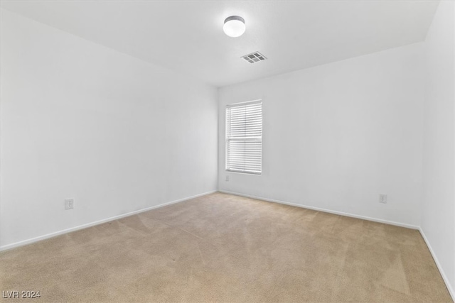 spare room featuring light colored carpet