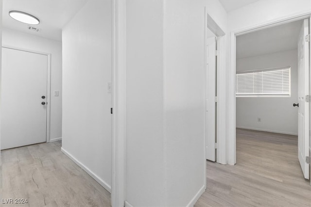 corridor with light hardwood / wood-style floors