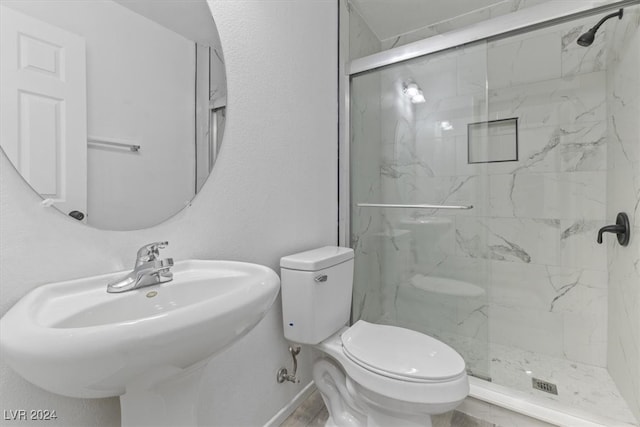 bathroom with toilet, an enclosed shower, and sink