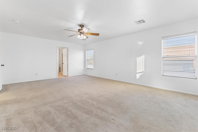 spare room with ceiling fan and light carpet