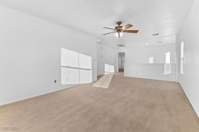 unfurnished living room featuring light colored carpet and ceiling fan