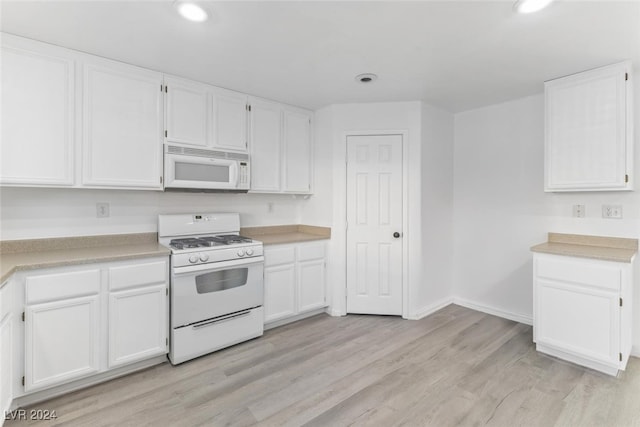 kitchen featuring white appliances, white cabinetry, and light hardwood / wood-style flooring