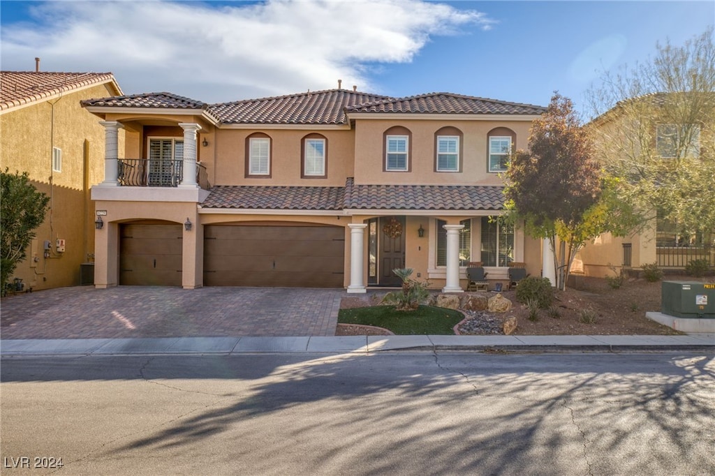 mediterranean / spanish-style home featuring a balcony and a garage