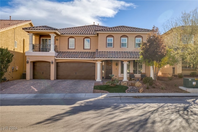 mediterranean / spanish-style home featuring a balcony and a garage