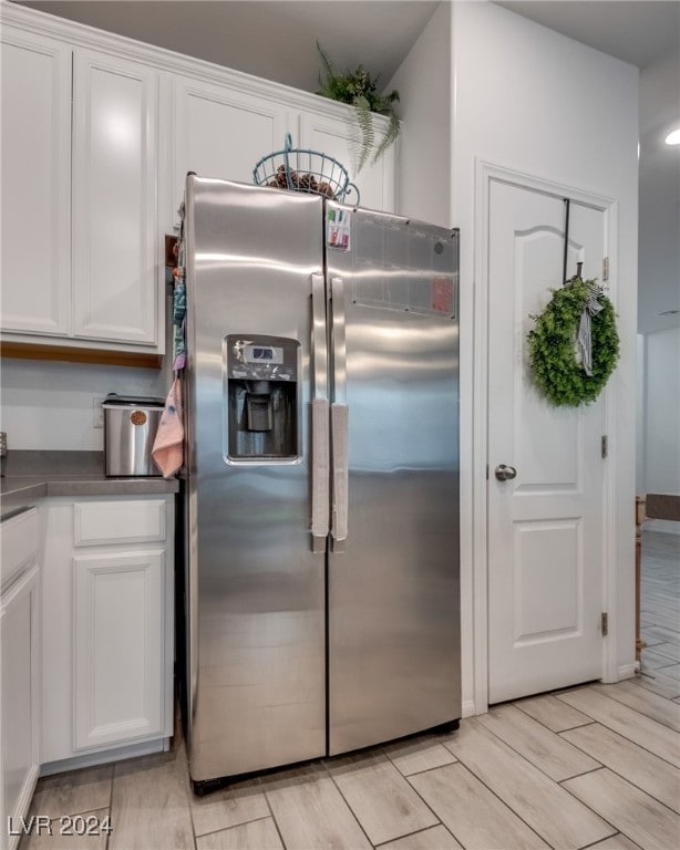 kitchen featuring light hardwood / wood-style floors, stainless steel refrigerator with ice dispenser, and white cabinets