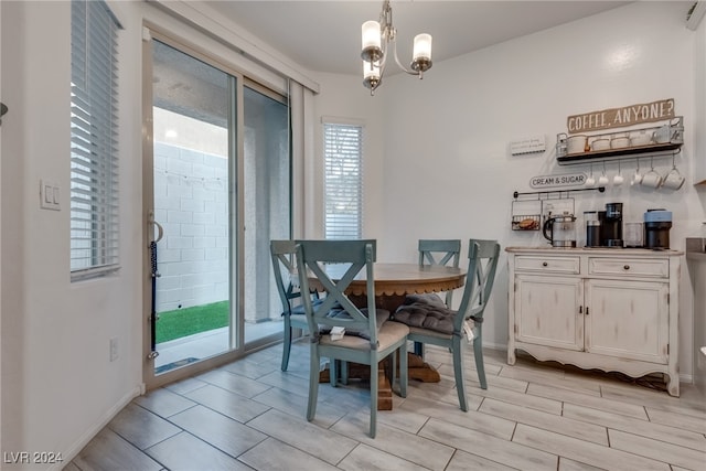 dining room featuring a healthy amount of sunlight, light hardwood / wood-style flooring, and an inviting chandelier