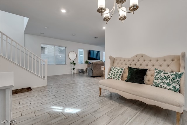 living room with light hardwood / wood-style floors and a notable chandelier