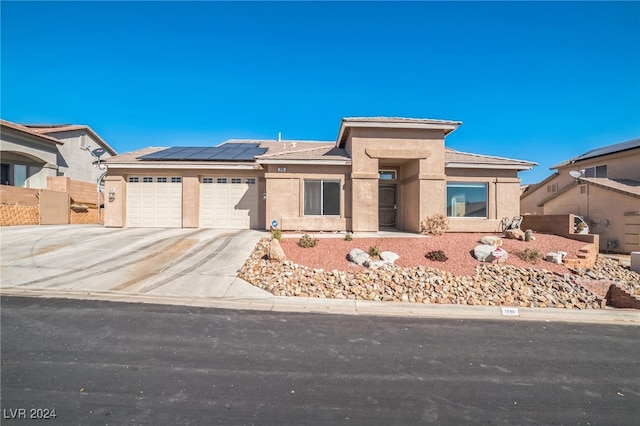 prairie-style home featuring solar panels and a garage