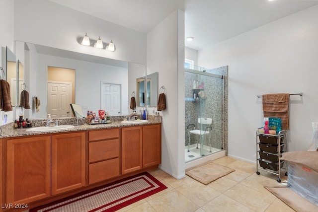 bathroom with tile patterned flooring, a shower with door, and vanity