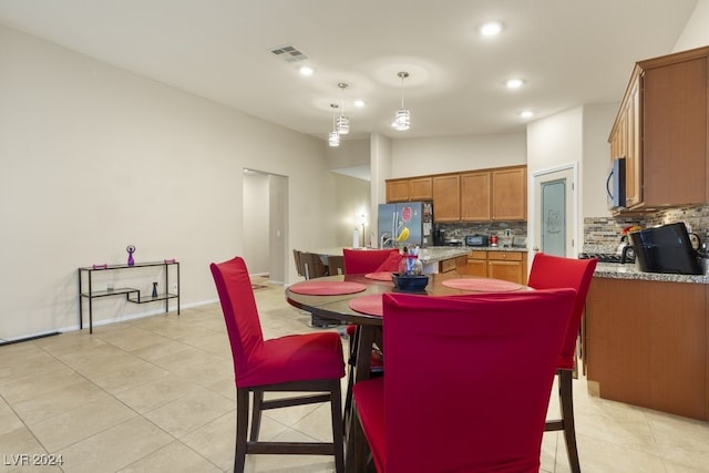 dining space with light tile patterned flooring and lofted ceiling