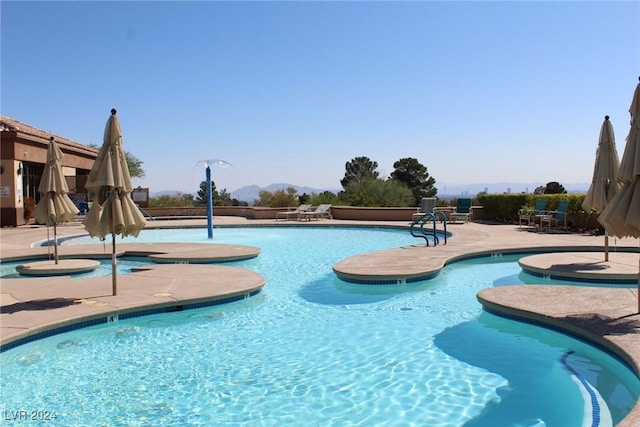 view of swimming pool featuring a patio area and a mountain view