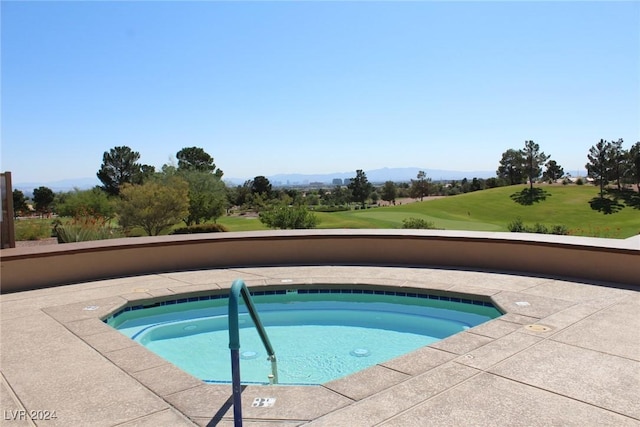 view of pool with a hot tub and a mountain view