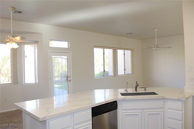 kitchen with sink, white cabinetry, dishwasher, light stone counters, and ceiling fan