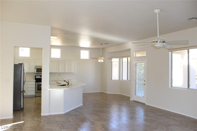 kitchen with appliances with stainless steel finishes, ceiling fan, white cabinetry, and plenty of natural light