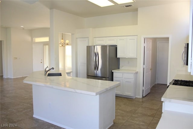 kitchen featuring stainless steel appliances, light stone countertops, a notable chandelier, sink, and white cabinetry