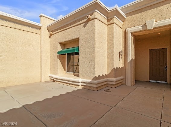 view of exterior entry featuring a patio