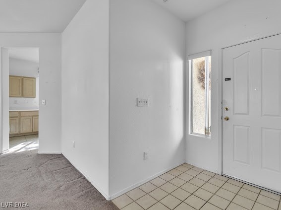 foyer featuring light colored carpet