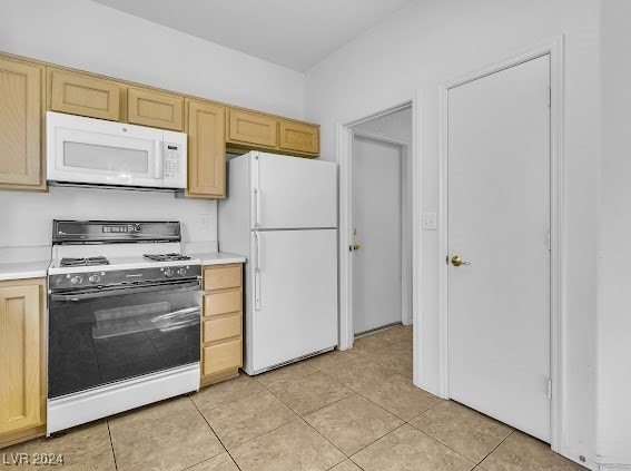 kitchen featuring white appliances, light brown cabinets, and light tile patterned floors