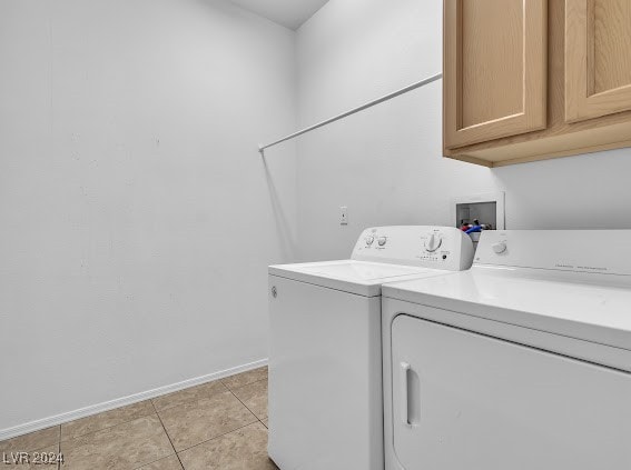 washroom with cabinets, light tile patterned floors, and washer and clothes dryer