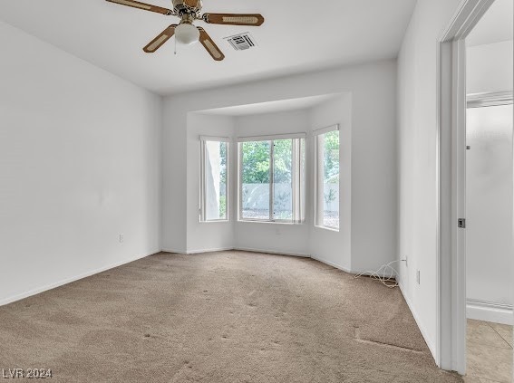 unfurnished room featuring ceiling fan and light colored carpet