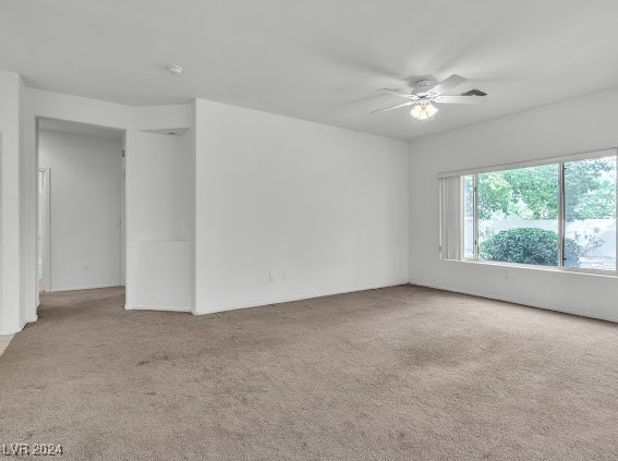 carpeted empty room featuring ceiling fan