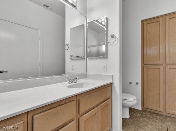 bathroom with vanity, tile patterned flooring, and toilet