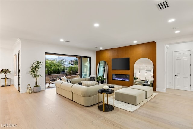 living room featuring crown molding and light hardwood / wood-style flooring