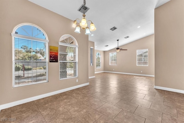 empty room featuring ceiling fan with notable chandelier, vaulted ceiling, and light tile patterned floors