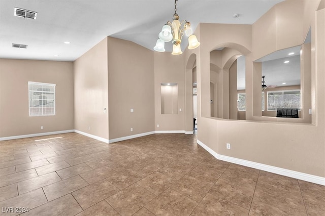 empty room featuring ceiling fan with notable chandelier and vaulted ceiling